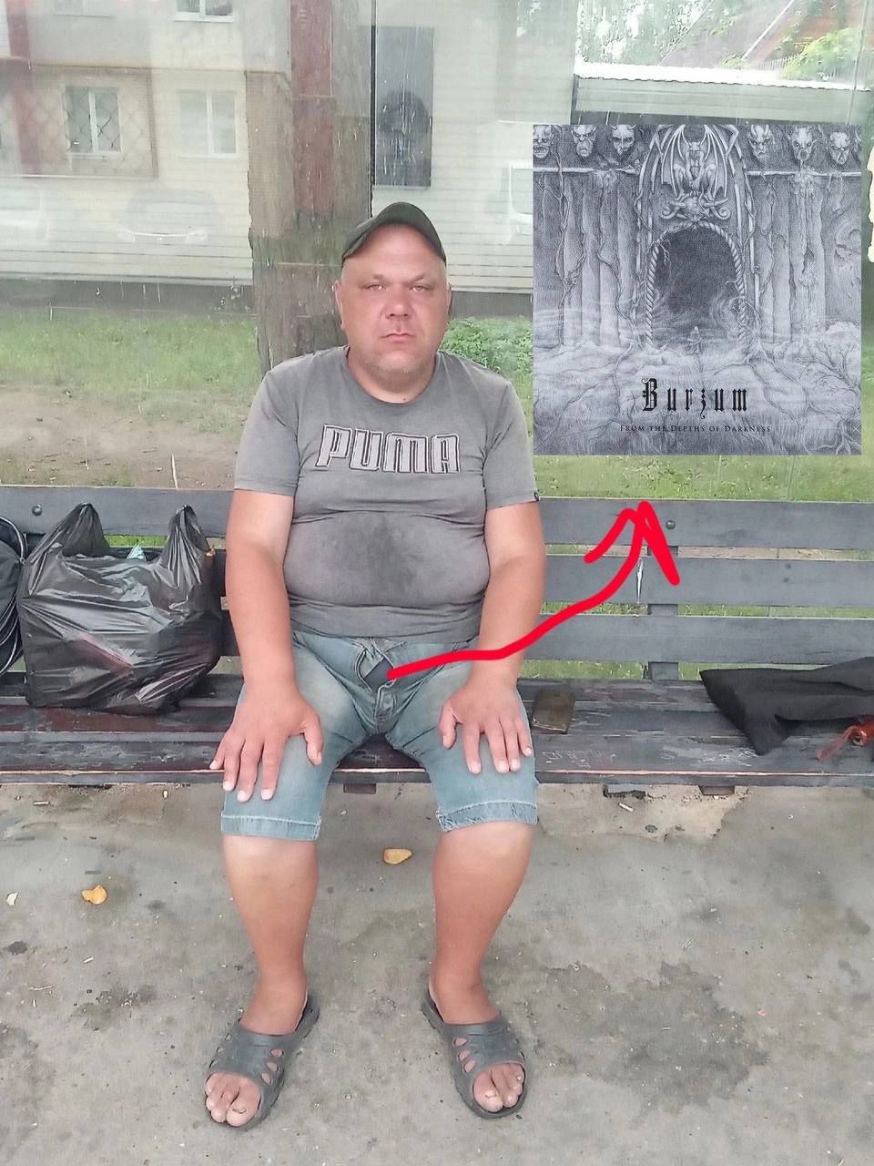 Мужик в шлепках и Burzum Мужчина в шлепках сидит на автобусной остановке, а рядом с ним висит постер группы Burzum