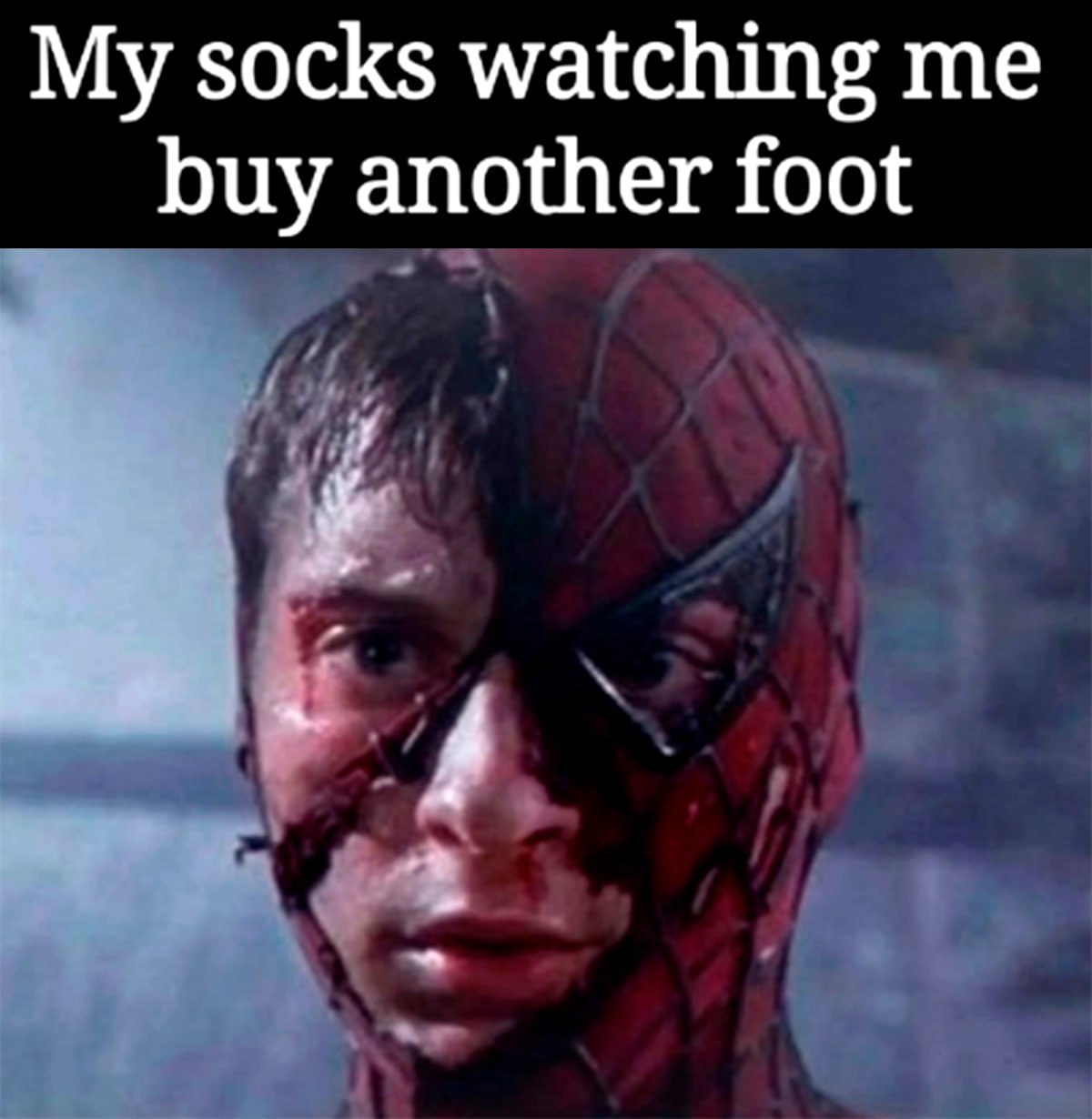 My socks watching me buy another foot Мем с Человеком-пауком в порванной маске и текстом «Мои носки смотрят, как я покупаю еще одну ступню»