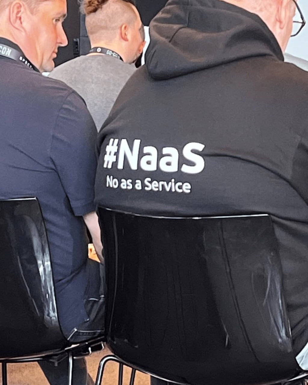 Надпись #NaaS No as a Service Человек в толстовке с надписью #NaaS No as a Service