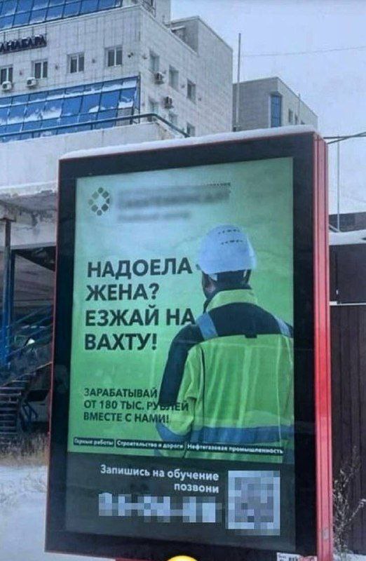 Надоела жена? Езжай на вахту! Мужчина в рабочей форме на рекламном плакате с надписью: Надоела жена? Езжай на вахту!