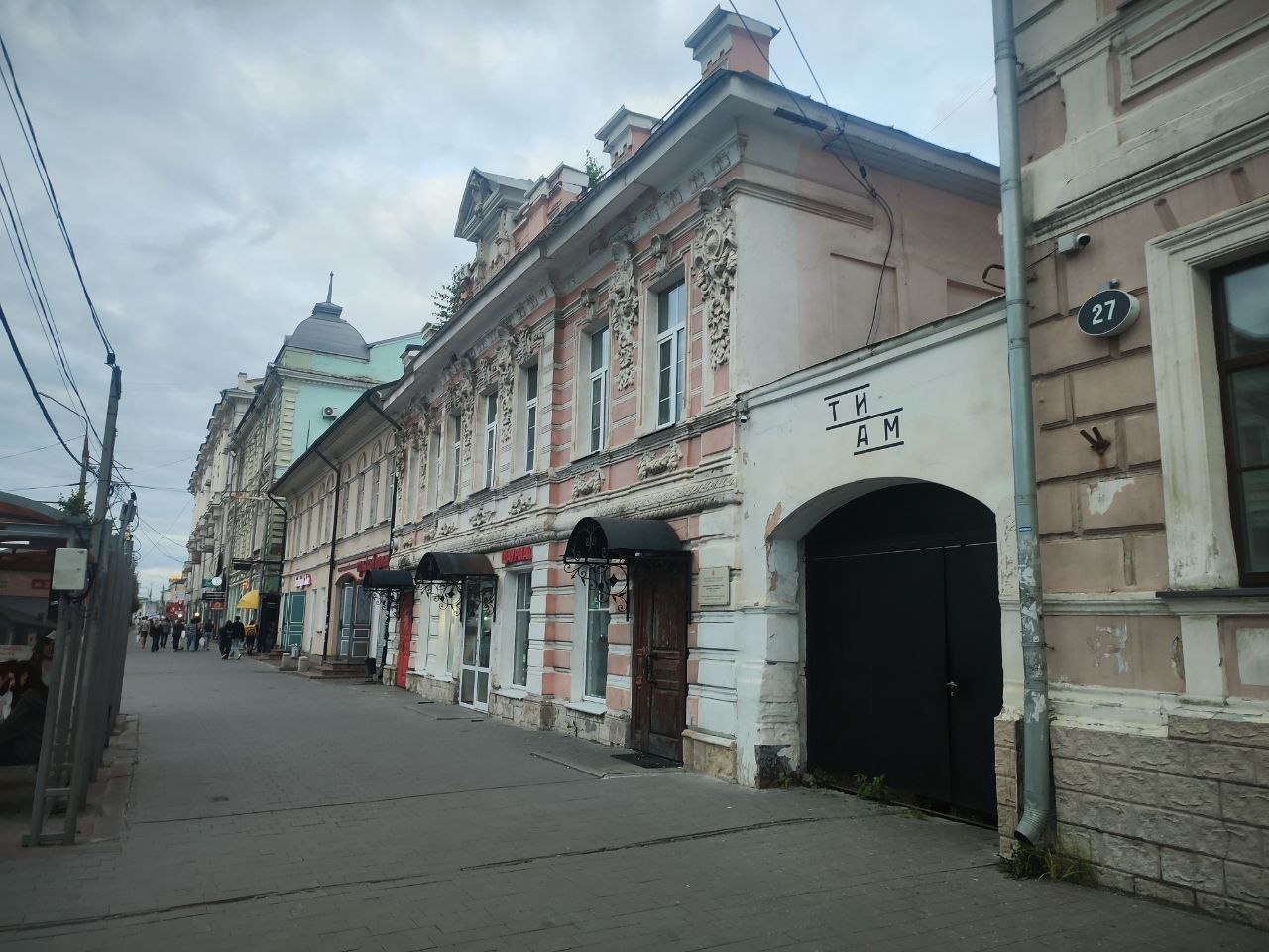 Старинная городская улица с арочным проездом и странной надписью «ТЙ АМ» на фасаде дома № 27.
