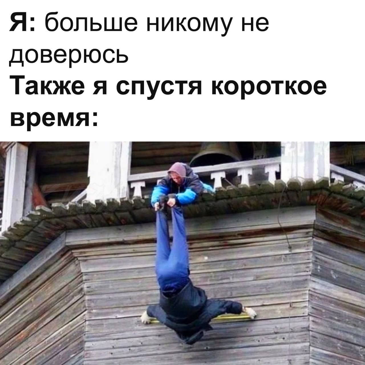 Я никому не доверюсь Человек держит другого за ноги, свисающего вниз головой со здания