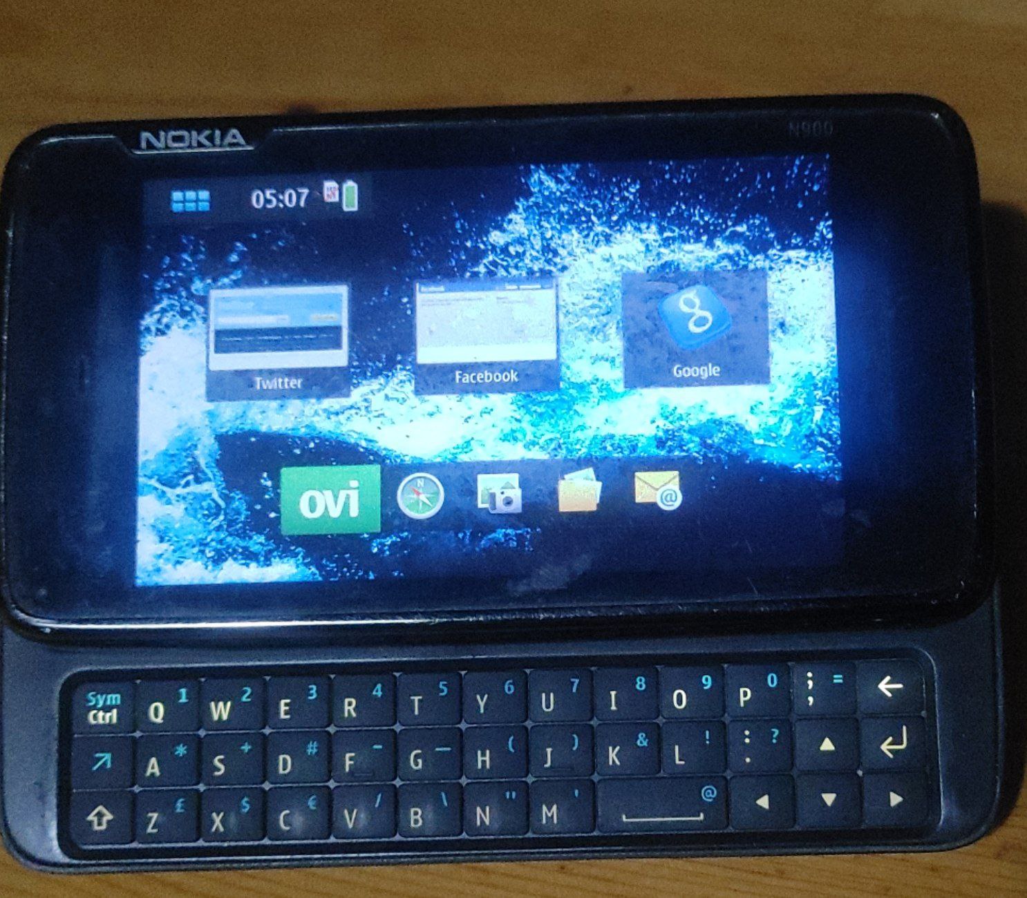 Nokia N900 Телефон Nokia N900 с выдвижной QWERTY-клавиатурой, изображенный крупным планом.