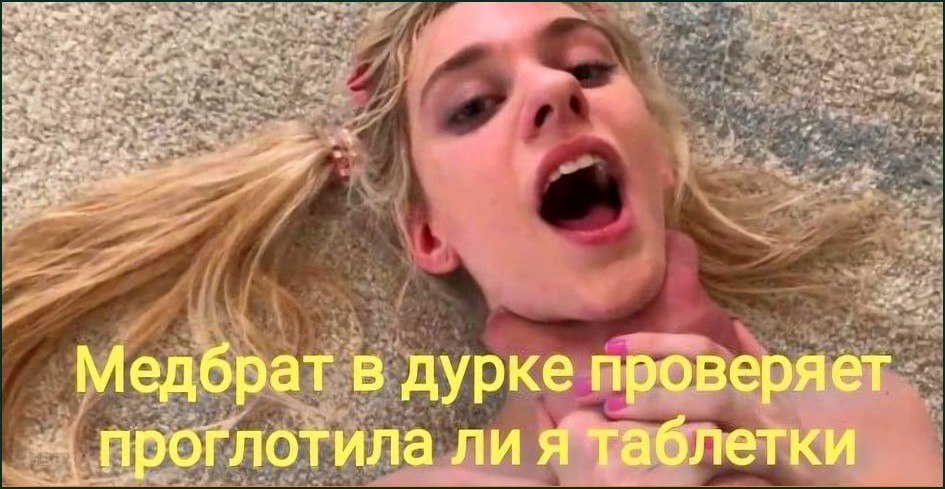 Девушка с открытым ртом лежит на полу: медбрат в психиатрической больнице проверяет, проглотила ли она таблетки.
