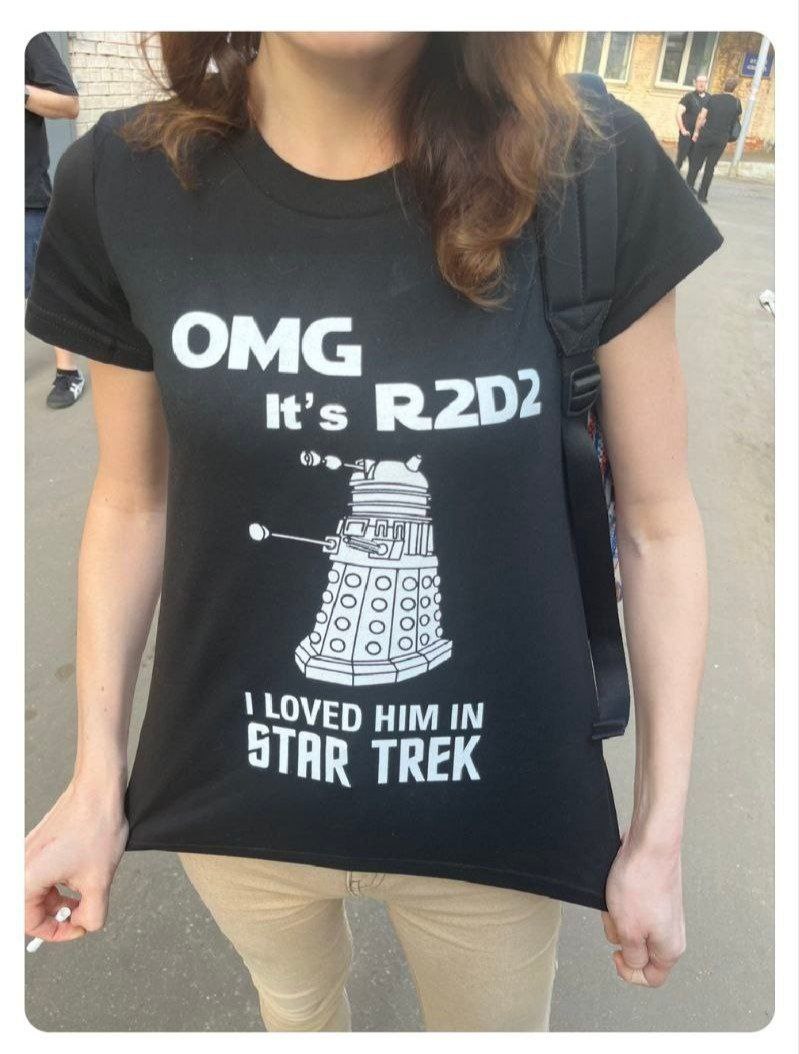 OMG it's R2D2, I loved him in Star Trek Девушка в черной футболке с надписью «OMG it's R2D2, I loved him in Star Trek», на которой изображен далекий из «Доктора Кто».