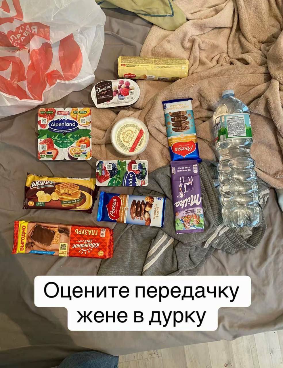 Разложенная на кровати передача с йогуртами, сладостями и водой и надписью «Оцените передачку жене в дурку».