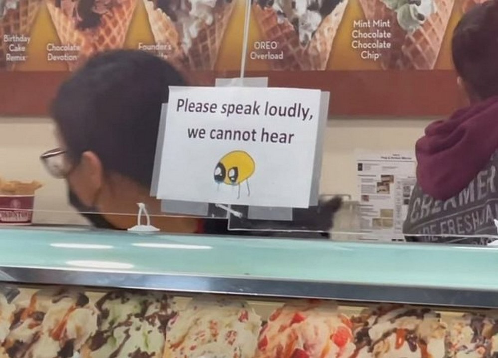 Please speak loudly, we cannot hear Вывеска в кафе-мороженом с просьбой говорить громче из-за масок