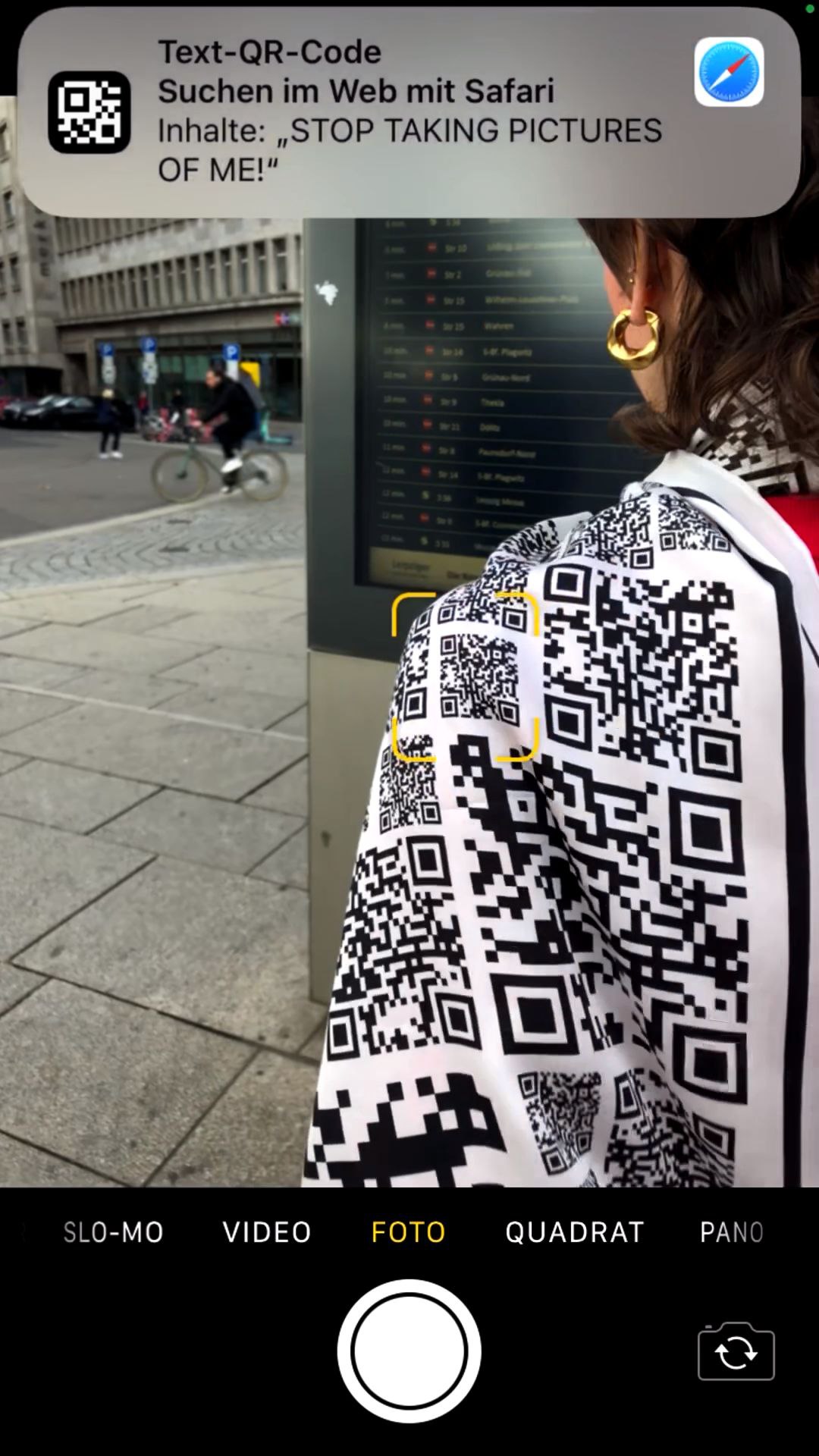 Пиджак из QR-кодов с надписью «Хватит меня фотографировать!» Девушка в пиджаке из QR-кодов, которые переводятся как «Хватит меня фотографировать!»