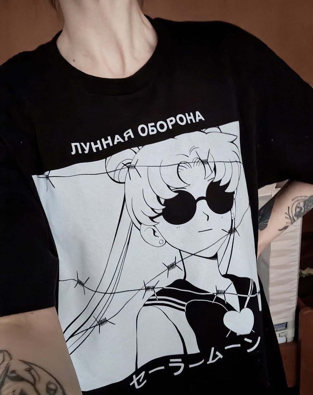 Сейлор Мун в очках и колючей проволоке Девушка в черной футболке с принтом Сейлор Мун в очках и колючей проволоке.