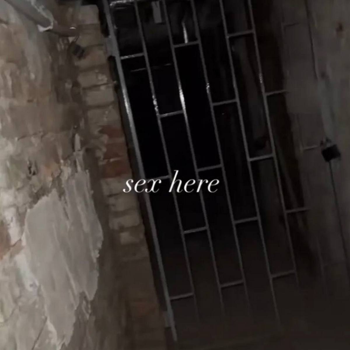 Sex here Темная заброшенная комната с надписью "sex here" на стене