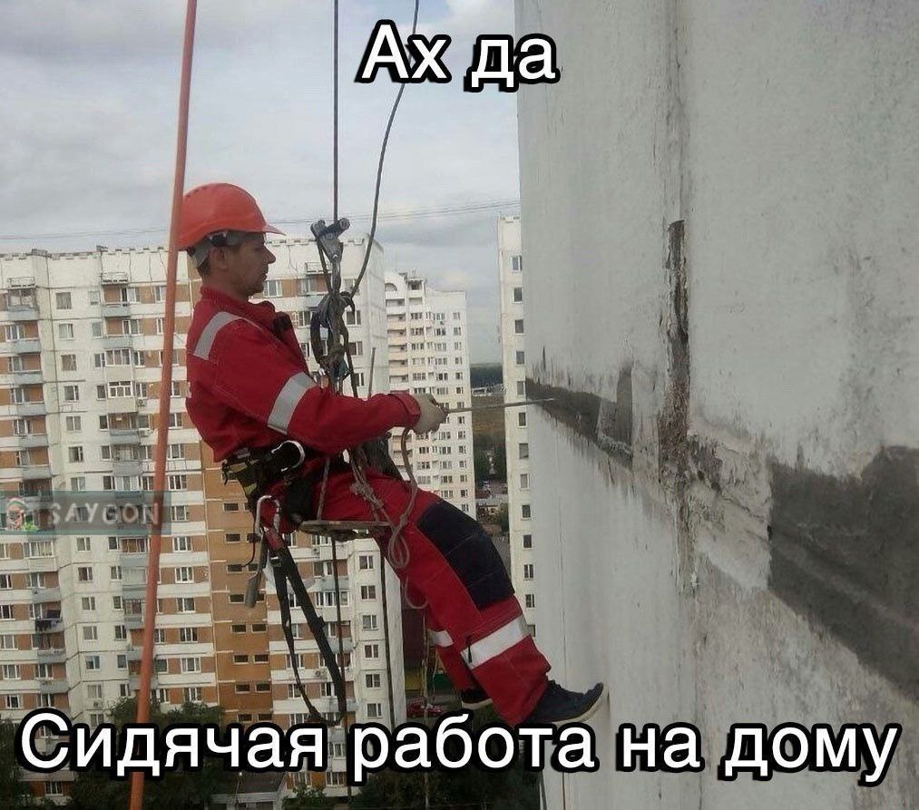 Сидячая работа на дому Мужчина-альпинист висит на веревках вдоль стены многоэтажного дома с надписью «Сидячая работа на дому».