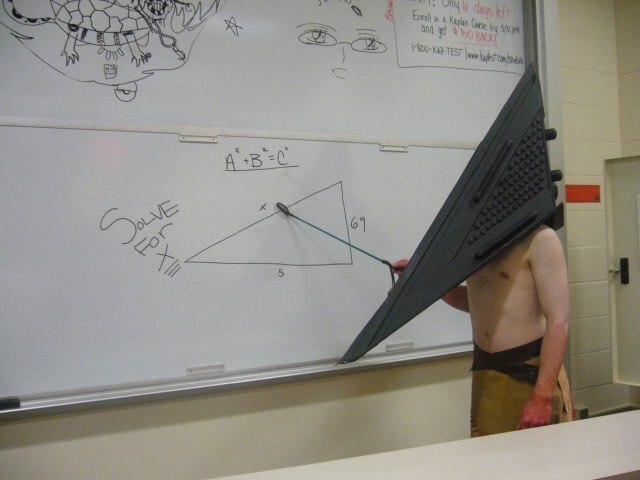 Полуголый персонаж с треугольной головой стоит у доски с задачей «Solve for x!» и выглядит как отсылка к Silent Hill
