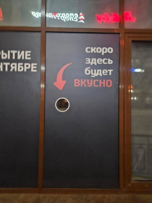 Надпись на двери обещает, что скоро здесь будет вкусно, а стрелка указывает на маленькое окошко.
