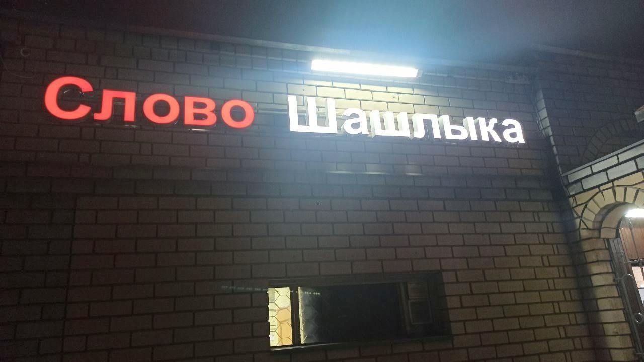 Слово шашлыка Вывеска на стене здания: слово шашлыка