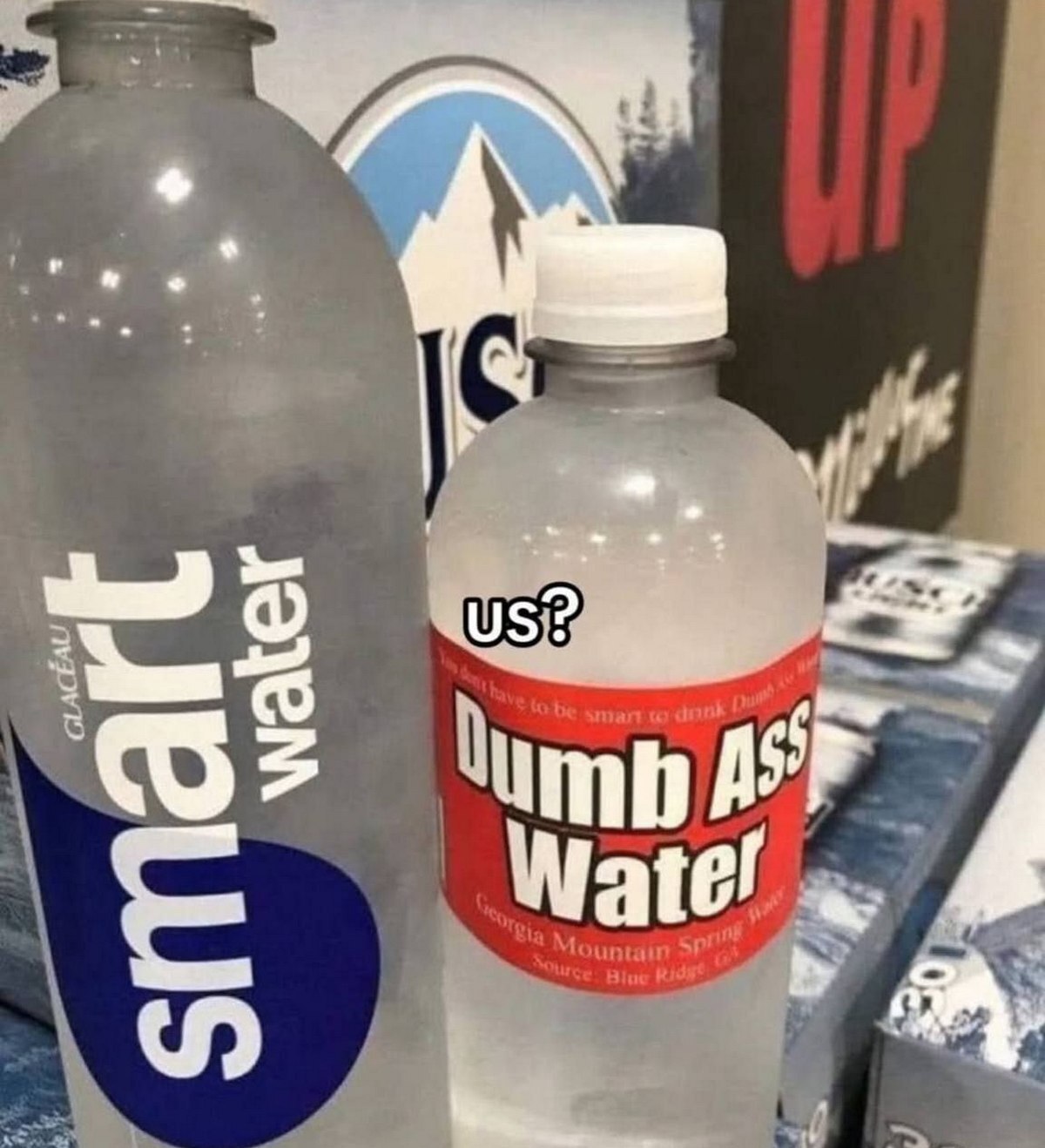 Smart Water vs Dumb Ass Water На переднем плане расположены две бутылки воды: "Smart Water" и "Dumb Ass Water". Надпись "us?" расположена над бутылкой "Dumb Ass Water".
