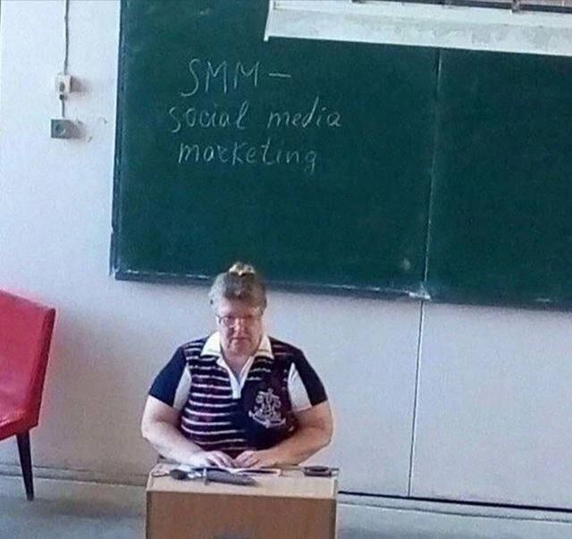Учительница SMM Надпись SMM - social media marketing на доске за учительницей