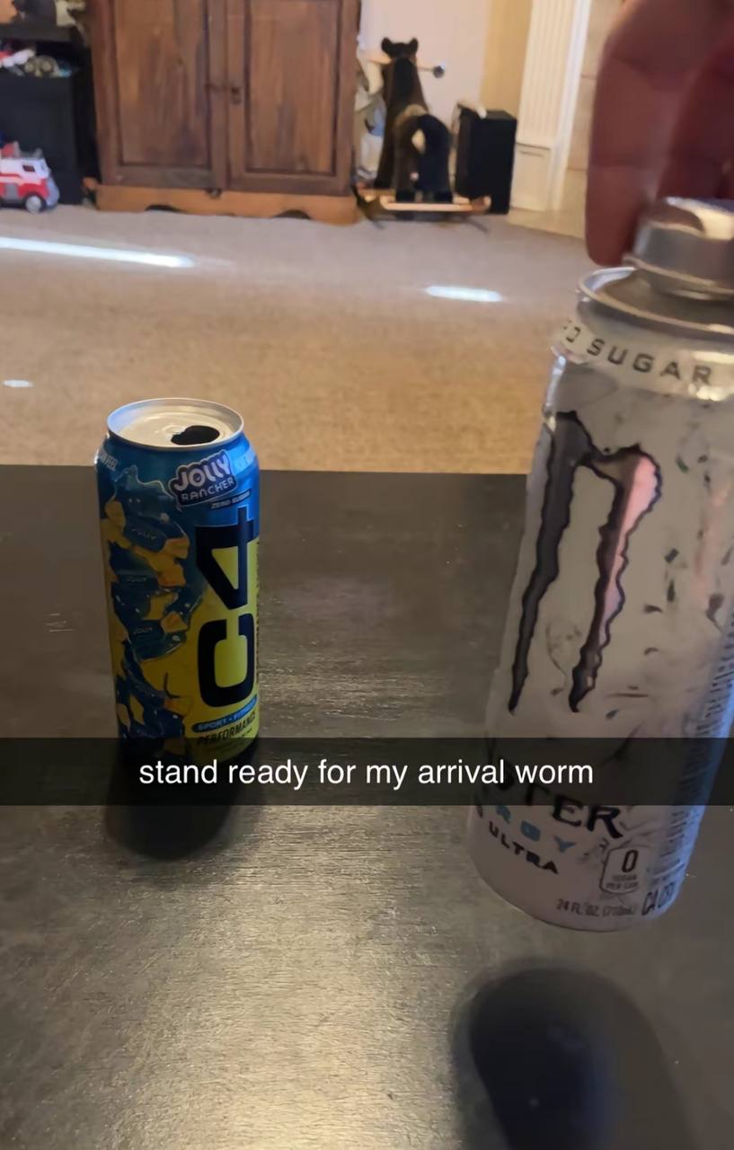 Stand ready for my arrival worm Две открытые банки энергетических напитков C4 и Monster Energy на столешнице с подписью "stand ready for my arrival worm".