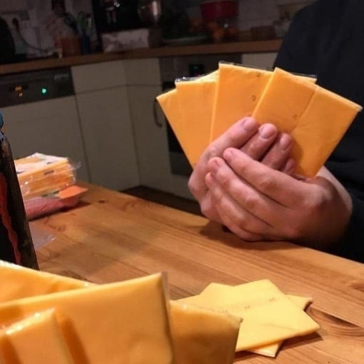 Сырная рука Руки, держащие ломтики сыра, как карты.