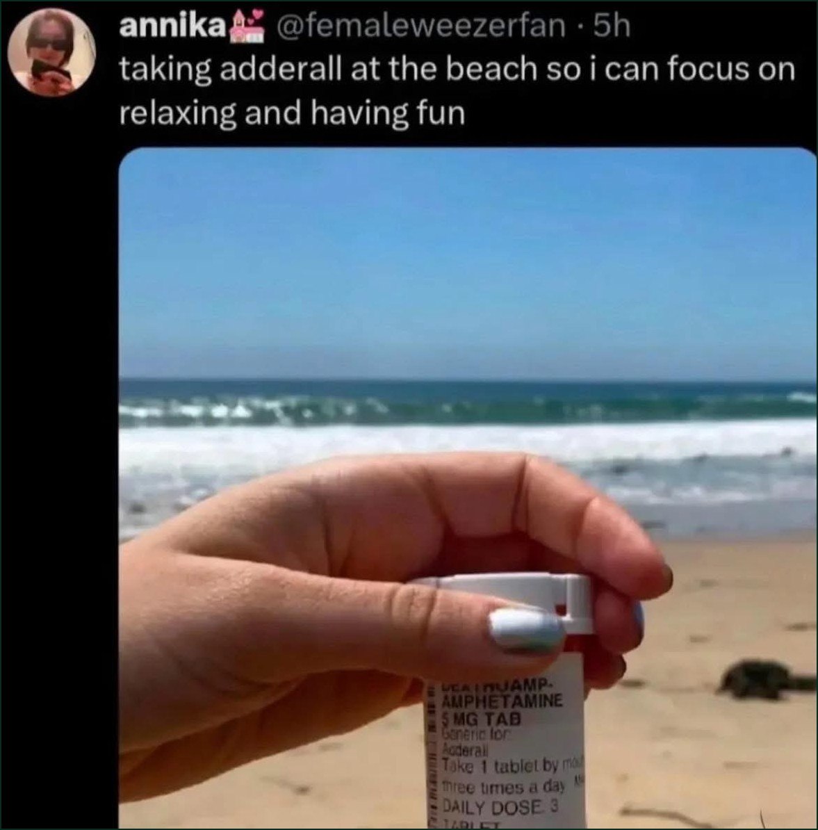 Человек принимает Adderall на пляже, чтобы сосредоточиться на расслаблении и веселье, держа упаковку амфетамина на фоне океана.