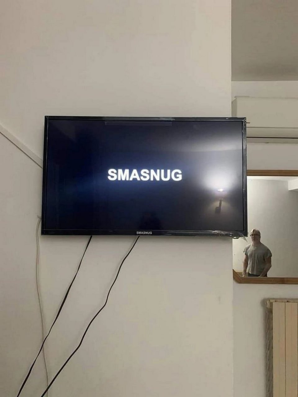 Телевизор Smasnug и отражение человека Телевизор с надписью Smasnug и отражение человека в очках, который смотрит на экран
