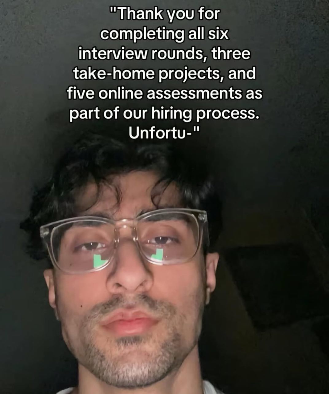 Thank you for completing all six interview rounds Unfortu- Мужчина в очках с надписью "Thank you for completing all six interview rounds, three take-home projects, and five online assessments as part of our hiring process. Unfortu-"