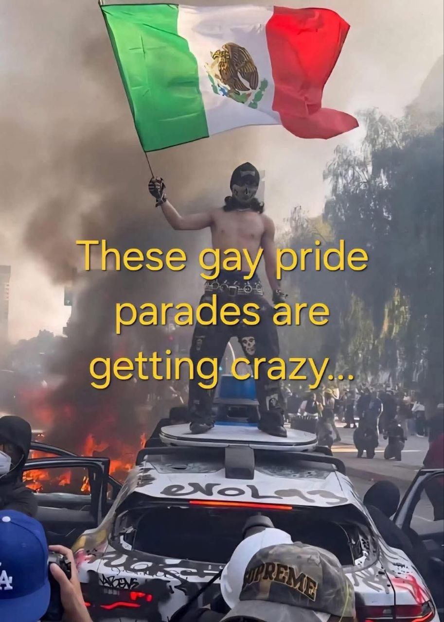 These gay pride parades are getting crazy Человек с флагом Мексики стоит на горящей машине