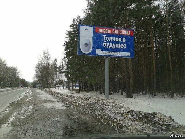 Реклама магазина сантехники с унитазом и слоганом «Толчок в будущее» на заснеженной дороге.