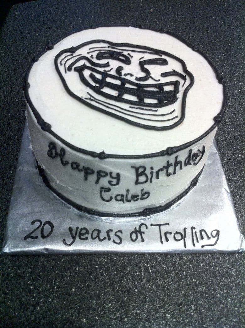 Торт с Троллфейсом и надписью 20 years of Trolling Круглый торт, украшенный белой глазурью, с изображением Троллфейса и надписью "Happy Birthday Caleb" и "20 years of Trolling" на подложке.