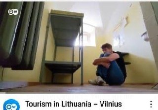 Парень сидит в пустой комнате, а внизу подпись: «Tourism in Lithuania – Vilnius» — «Туризм в Литве — Вильнюс»