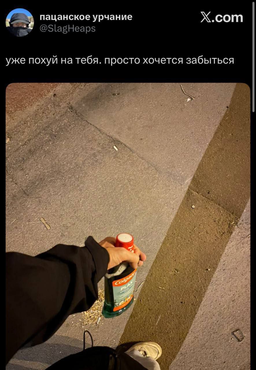 Уже похуй на тебя. просто хочется забыться Человек держит бутылку "Colgate Plax" и смотрит на дорогу с надписью "уже похуй на тебя. просто хочется забыться"