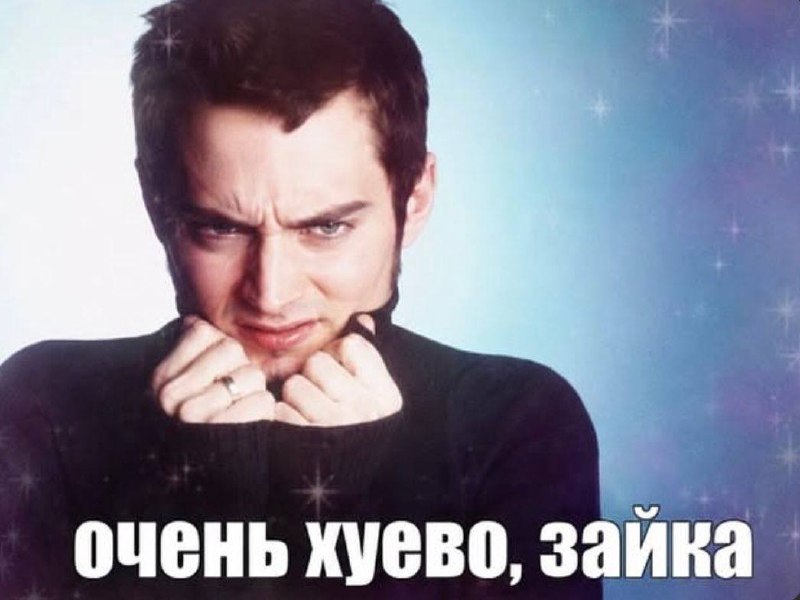 Молодой мужчина хмурится и держится за ворот свитера с подписью «Очень хуево, зайка».