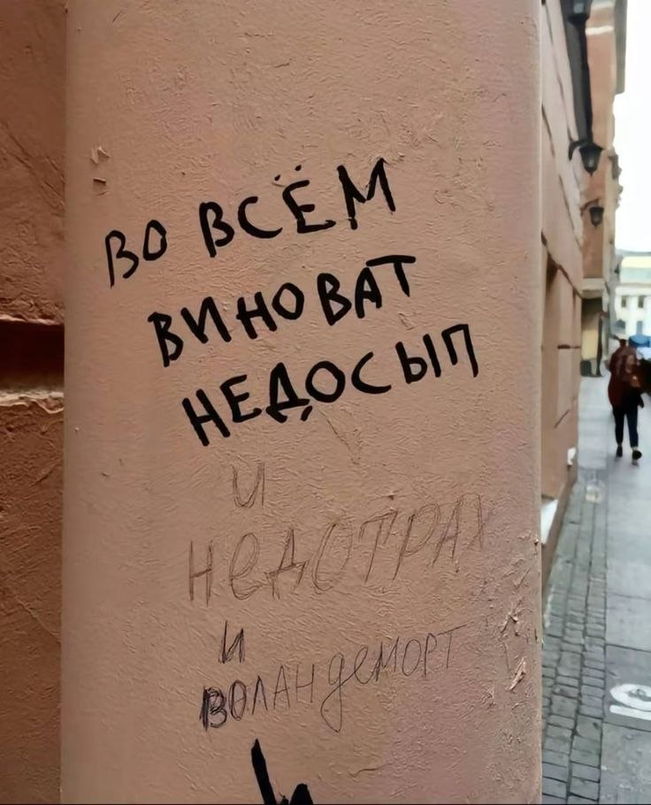 Надпись на стене «Во всём виноват недосып» с забавными бледными приписками снизу