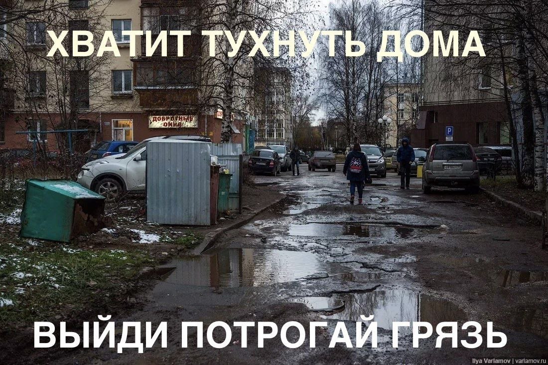 Ироничный призыв выйти из дома и потрогать грязь во дворе с лужами, мусорными контейнерами и разбитой дорогой.