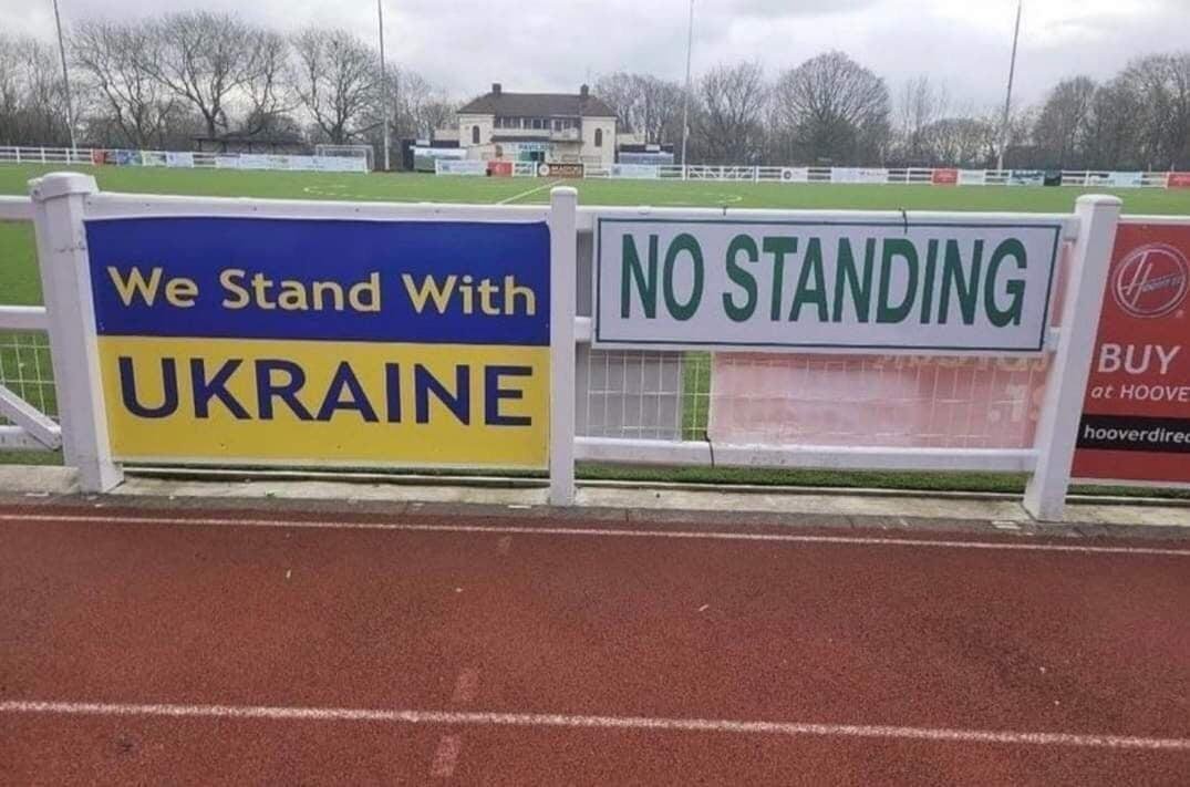 Мы поддерживаем Украину. Стоять запрещено Мем с надписями "Мы поддерживаем Украину" и "Стоять запрещено" на спортивном стадионе