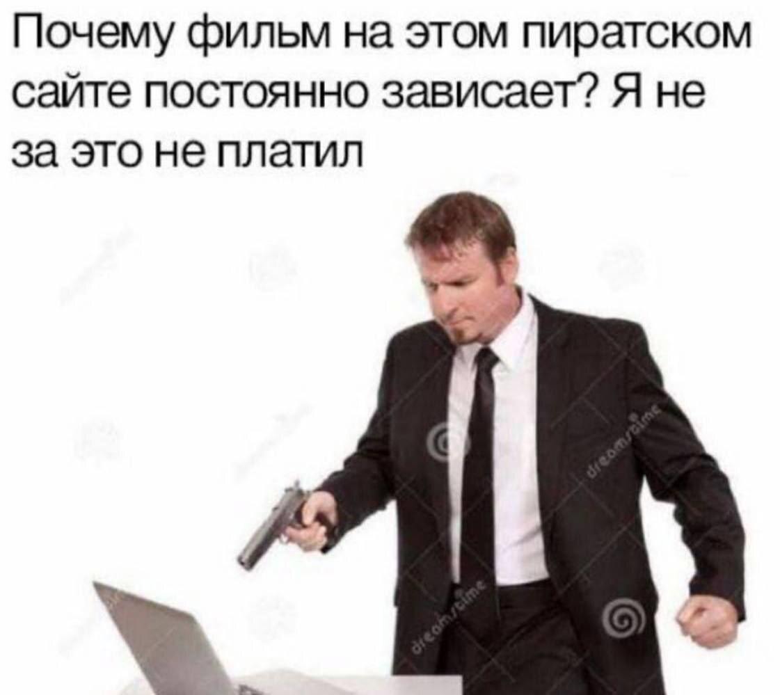 Я не за это не платил Мужчина в костюме угрожает пистолетом ноутбуку из-за того, что фильм на пиратском сайте зависает
