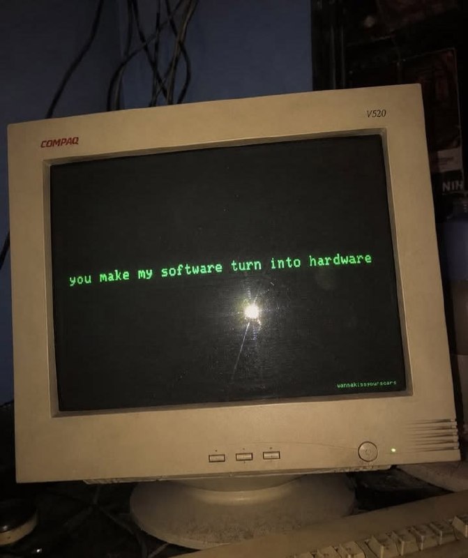 Старый монитор Compaq с зелёной надписью «You make my software turn into hardware» на чёрном экране