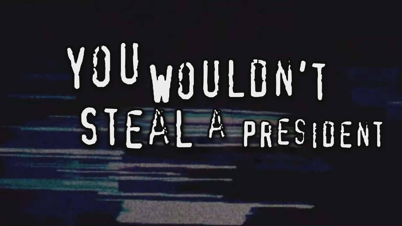 Мрачная надпись «You wouldn’t steal a president» на фоне VHS-помех — пародия на антипиратский слоган.