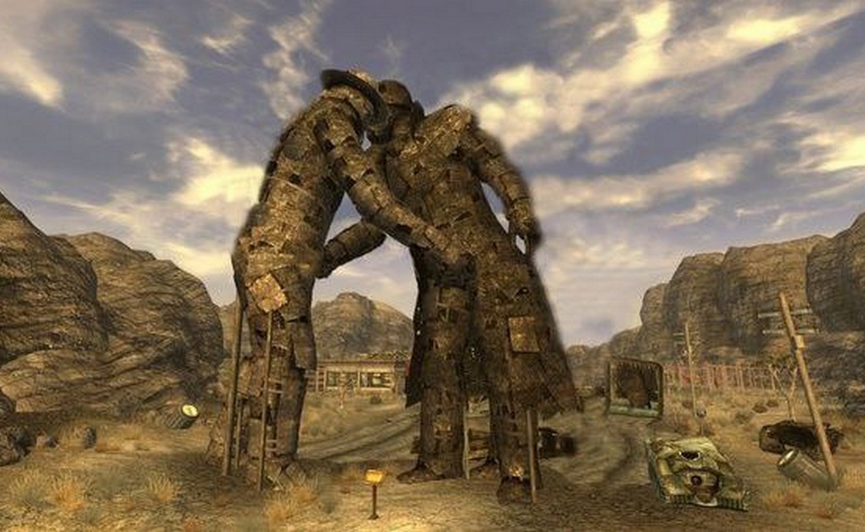 Целующиеся статуи Fallout: New Vegas Две статуи, сделанные из обломков металла, стоят, обнявшись посреди пустынного пейзажа игры Fallout: New Vegas. Одна из статуй, похоже, изображает ковбоя в шляпе.